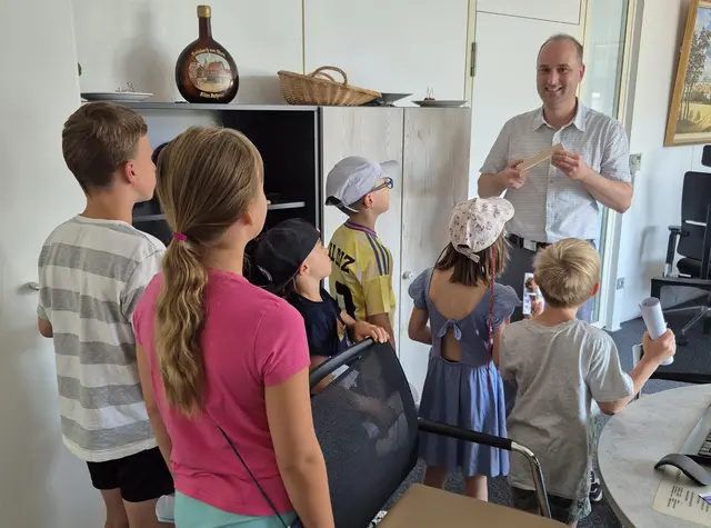 Die Sulzbacher Ferienspiele zu Gast im Sulzbacher Bürgermeisterbüro: Markus Krebs zeigt den Kindern ein in Sulzbach gefertigtes Ibelo-Feuerzeug.  | Foto: Markt Sulzbach a.Main
