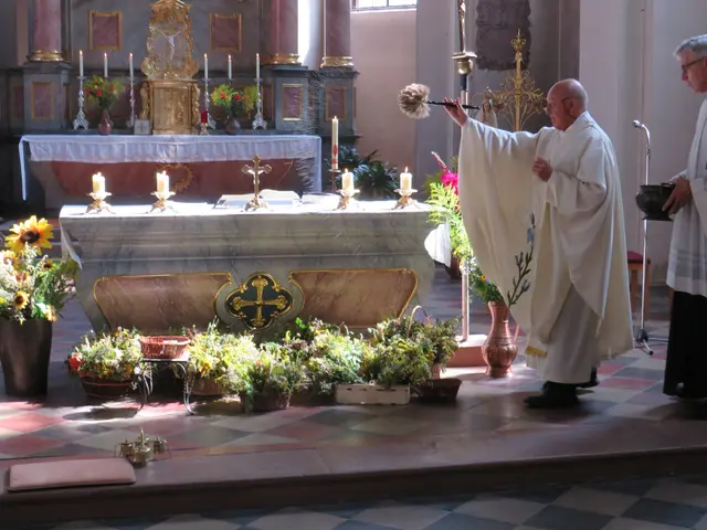 Pfarrer Kleinhenz segnet die Kräuterbuschen mit Weihwasser | Foto: Nina Reuling
