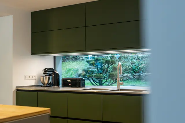 Olivgrüner Küchentraum und Insel in Edelstahlsonderbau von WM Küchen + Ideen