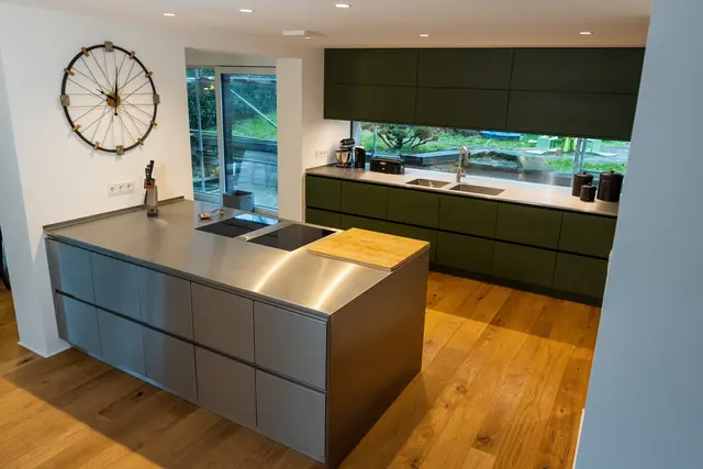 Olivgrüner Küchentraum und Insel in Edelstahlsonderbau von WM Küchen + Ideen