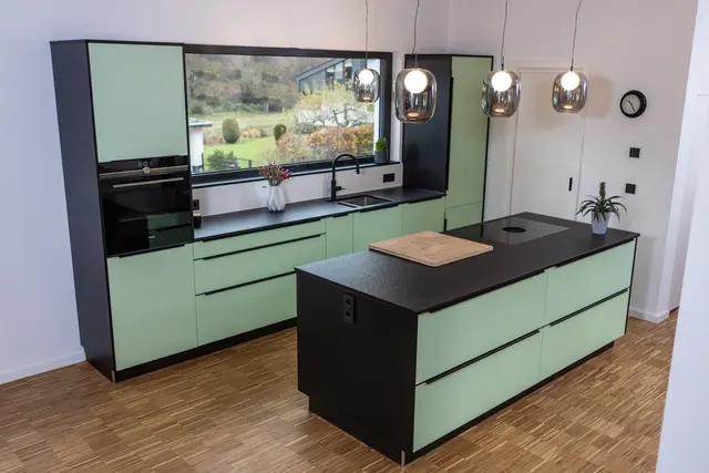 Mintgrün mit Schwarz kombinierte Küche von WM Küchen + Ideen