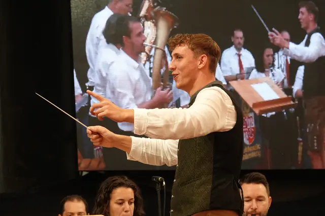 Bei der gegenwärtigen Miltenberger Michaelismesse wechseln die Dirigenten, einerseits weil verschiedene Musikgruppen auf der Bühne agieren und verständlicherweise eine Stabführung brauchen. 
Andererseits ist es eine besondere Ehre eine Blaskapelle dirigieren zu dürfen, beispielsweise am Handwerkertag am 1. September 2025 im Festzelt.