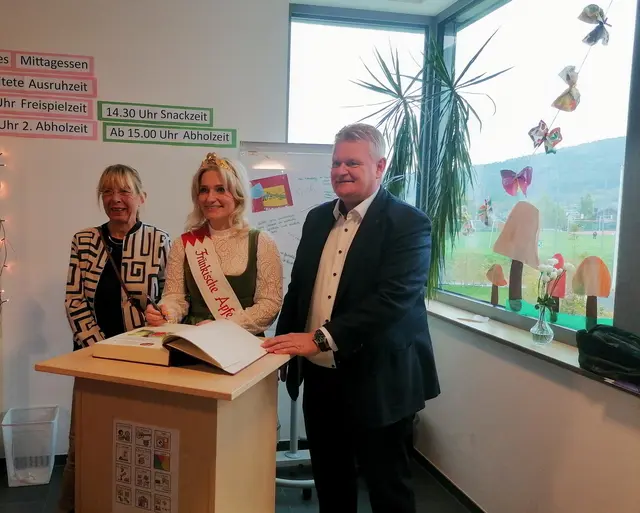 Apfelkönigin Theresa II trägt sich in das Goldene Buch des Marktes Eschau ein. Mit dabei sind Bürgermeister Gerhard Rüth und die stv. Landrätin Monika Wolf-Pleßmann. | Foto: Anke Schaub