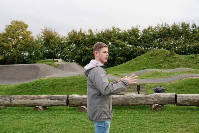 Tom Donaubauer (24), „Local Hero und Bikepark-Legende“ - Projektbesichtigung: Bikepark als Vorzeigeprojekt 
Den Auftakt der Versammlung bildete eine Besichtigung des LEADER-geförderten Projekts „Bikepark des FC Hundheim/Steinbach 1952 e.V.“. Die Mitglieder zeigten sich beeindruckt von dem Engagement des Vereins und der positiven Wirkung des Projekts für die örtliche Jugend und den Freizeitbereich. Der Hundheimer Biker Tom Donaubauer (24 Jahre alt) erläuterte die sehr gut besuchte, speziell für Jugendliche eingerichtete Freizeit-Anlage. 
Foto Roland Schönmüller 