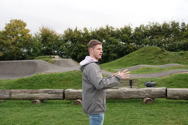 Tom Donaubauer (24), „Local Hero und Bikepark-Legende“ - Projektbesichtigung: Bikepark als Vorzeigeprojekt 
Den Auftakt der Versammlung bildete eine Besichtigung des LEADER-geförderten Projekts „Bikepark des FC Hundheim/Steinbach 1952 e.V.“. Die Mitglieder zeigten sich beeindruckt von dem Engagement des Vereins und der positiven Wirkung des Projekts für die örtliche Jugend und den Freizeitbereich. Der Hundheimer Biker Tom Donaubauer (24 Jahre alt) erläuterte die sehr gut besuchte, speziell für Jugendliche eingerichtete Freizeit-Anlage. 
Foto Roland Schönmüller 