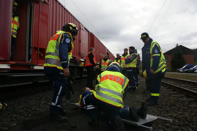 Der Patient wird mit Hilfe einer Einheitskrankentrage an den Rettungszug übergeben. | Foto: Stefan Wolf