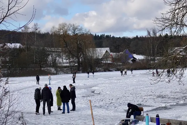 Über dem ehemaligen Klosterteich in Walldürn-Gottersdorf liegt eine dünne Eisdecke, in deren Mitte sich eine kleine Schar mutiger Schlittschuhläufer und Eishockeyspieler tummelt. Die Szenerie wirkt beinahe filmisch, wäre da nicht die beklemmende Leere am eisfreien Rand.
