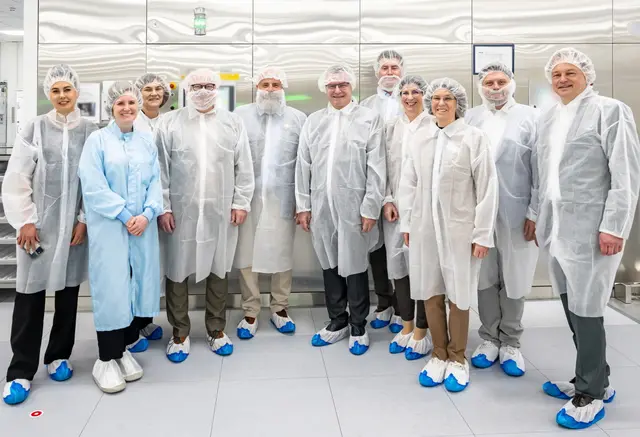 Da bei Alcon unter Reinraumbedingungen produziert wird, wurden die Gäste des Landrätetreffens passend eingekleidet. Das Bild zeigt die Landräte mit ihren Büroleitungen, Alcon-Geschäftsführer Stefan Schmittner (rechts) und drei Mitarbeiterinnen von Alcon (links). 

 | Foto: Winfried Zang