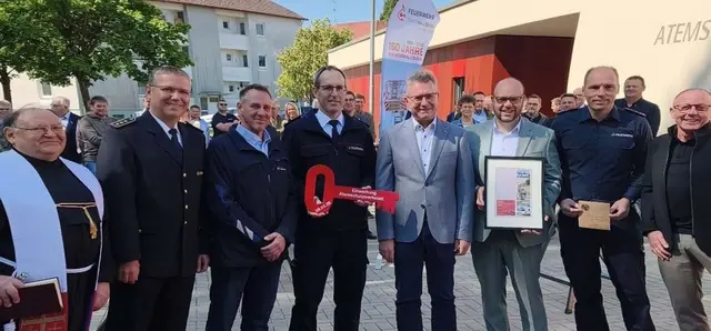 Das Bild zeigt Gäste bei der symbolischen Schlüsselübergabe zur Einweihung der Atemschutzwerkstatt