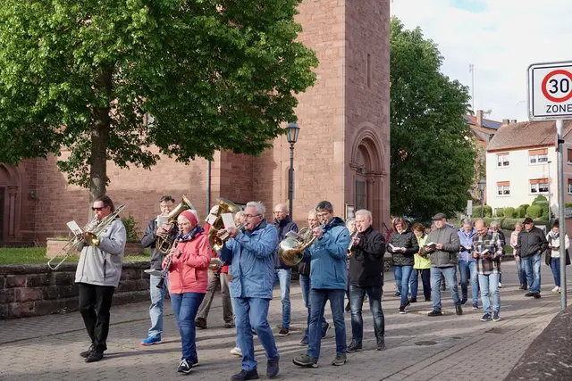 Vor der Pfarrkirche St. Bilhildis setzte sich der Zug in Bewegung, angeführt von Pfarrvikar Krzysztof Winiarz und begleitet von der hiesigen Musikkapelle, deren warmer Klang den Ort erfüllte.
