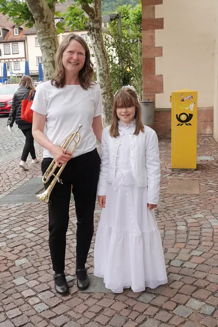 Musikalisch wird die Feier in Miltenberg traditionell von der Stadtkapelle getragen; genau diese Verbindung aus Stadtraum, Musik und liturgischem Ernst macht den besonderen Ton der Prozession aus. Wo sonst Geschäftigkeit herrscht, entsteht für eine Stunde eine andere Ordnung: Gebet statt Eile, Gesang statt Durchgangsverkehr, Birkengrün und Blumenschmuck statt bloßer Dekoration. 