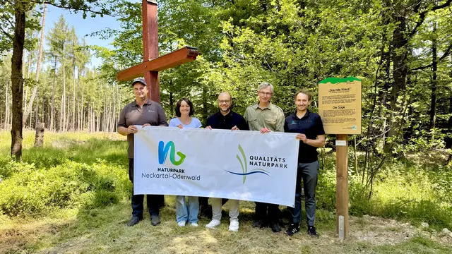 Das Bild zeigt Mitarbeitende der Stadt, Forst und Naturpark im Wald mit einem Infobanner vor einem neuen Infoschild
