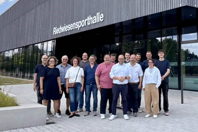 Das Bild zeigt mehrere Teilnehmende der Exkursion vor der Riedwiesensporthalle