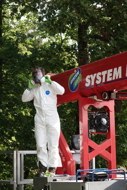 Mit einer Hebebühne, Schutzanzug, Handschuhen, Spezial-Brille und einer besonderen Sauger-Vorrichtung arbeiteten sie mehrere Meter über dem Boden. Der Mann auf der Bühne wirkte in seiner Schutzausrüstung fast wie ein Astronaut: konzentriert, abgeschirmt und mit großem Abstand zu einer Gefahr, die mit bloßem Auge oft kaum zu erkennen ist.