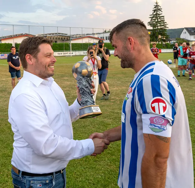 Landrat Björn Bartels gratulierte Faulbachs Spielführer Michael Pfandler zum Sieg im Landkreispokalfinale. | Foto: Winfried Zang