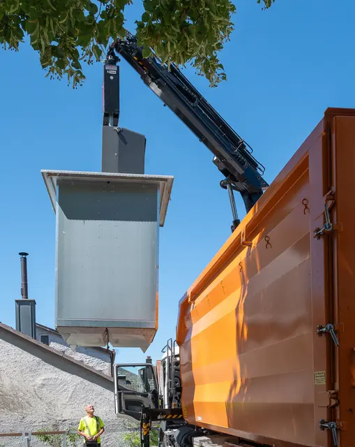 Der fünf Kubikmeter fassende Müllcontainer wird mit dem Kran hochgehoben und in den Abrollbehälter des Lastwagens entleert.  | Foto: Winfried Zang