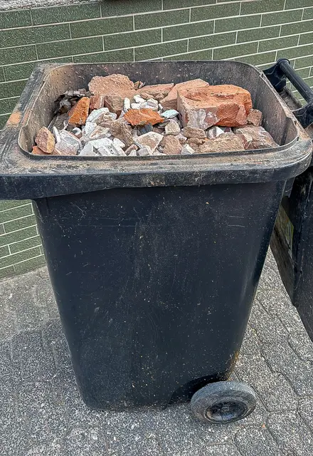 So geht es auf gar keinen Fall: Diese Restmülltonne wurde mit Bauschutt gefüllt, obwohl dieser nicht auf diese Weise entsorgt werden darf. Bis zu 200 Kilogramm dieses Materials dürfen täglich gebührenfrei auf die Wertstoffhöfe des Landkreises gebracht werden.  | Foto: Kommunale Abfallwirtschaft