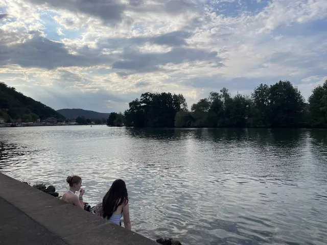 Ein Bild, das bleibt.

Zwei junge Mädchen am Mainufer. Die Füße im Wasser, ein Erfrischungsgetränk in der einen Hand, das Handy in der anderen. Sie reden leise, lachen, schauen auf den Fluss. Ein Bild, das den ganzen Tag in sich trägt: die Hitze, die Leichtigkeit, die Vorfreude, den Fluss, der alles verbindet.