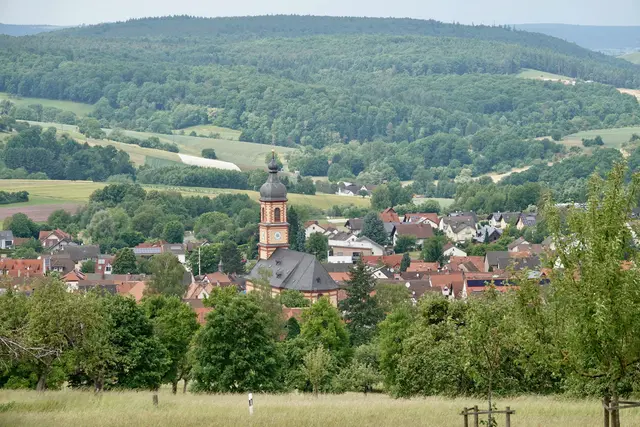 In Mönchberg wird diese alte Schwelle zwischen Sommerfülle und Herbstahnung bis heute auf besondere Weise erfahrbar. Der Bartholomäusmarkt ist dort mehr als ein Einkaufs- oder Festsonntag. Er ist ein Stück Ortsgedächtnis. Man trifft sich, bleibt stehen, kostet, schaut, plaudert, hört Musik, begleitet Kinder zu den Angeboten und merkt dabei, wie sehr ein Markt auch Zusammenhalt sichtbar machen kann. 