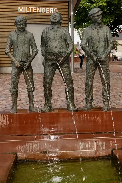 12
Drei junge Burschen, in Bronze gegossen, stehen auf einer Treppe, als hätte man sie mitten in
einem Schabernack erwischt. Warm im Ton, schwer im Gewicht, ein Denkmal, das
schmunzelt, ohne zu spotten.
A) Staffelbrunser
B) Mainbrunser
C) Turmbrunser