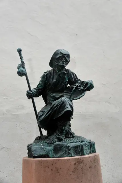 9
Vor der Kirche steht ein Pilger, der aussieht, als sei er gerade angekommen – oder kurz davor
aufzubrechen. Muschel und Stab erzählen von Wegen, die weiterführen als der Blick reicht.
A) Franziskusdenkmal
B) Nikolausdenkmal
C) Jakobusdenkmal