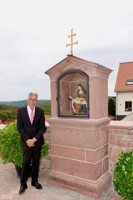 Dass der hiesige Kirchplatz um ein wahres Schmuckstück reicher ist, verdankt das Dorf vor allem einem Mann. Willi Schlegel, rühriger Mesner und leidenschaftlicher Hauptinitiator, blickte mit berechtigtem Stolz auf das vollendete Werk. Ihm gelang es, die Dorfgemeinschaft für dieses Vorhaben zu entflammen. 