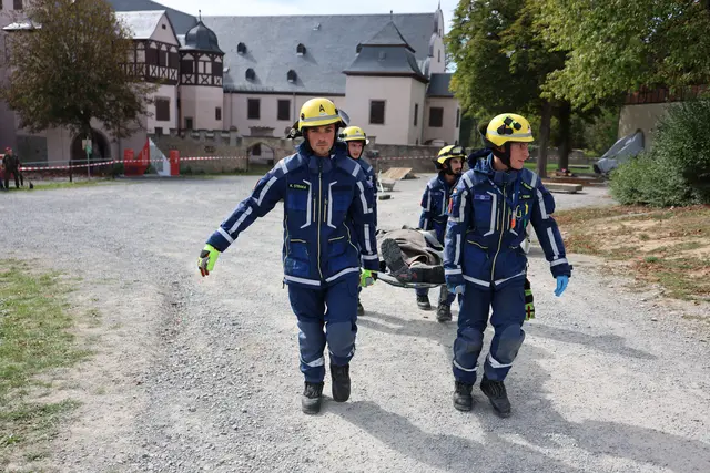 Nach der Rettung aus dem Gebäude bringen THW-Kräfte eine verletzte Person auf einer Trage aus dem unmittelbaren Einsatzbereich.  | Foto: THW Miltenberg