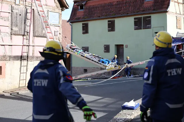 Mit vereinten Kräften bringen die THW-Einsatzkräfte eine verletzte Person sicher aus dem Obergeschoss des beschädigten Gebäudes.  | Foto: THW Miltenberg