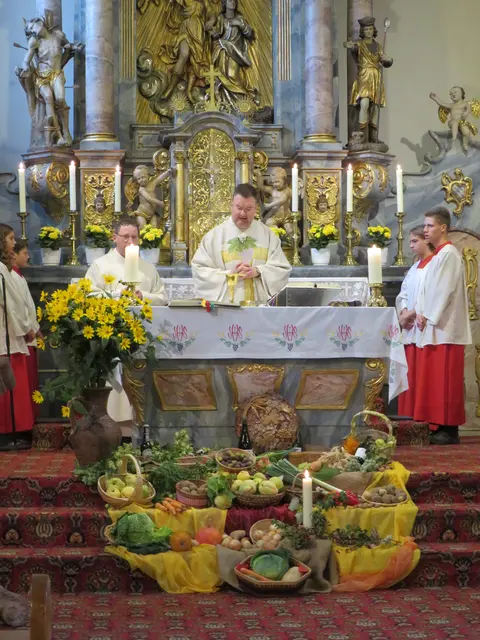 Pfarrer Jan Kölbel bei der Gabenbereitung; die Erntegaben im Vordergrund bereichern den Altar | Foto: Nina Reuling