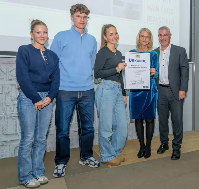 Ministerialbeauftragter Marcus Ramsteiner überreichte Schulleiterin Katja Wehner-Theinert sowie drei Vertreterinnen und Vertreter aus der Schülerschaft eine Urkunde für besondere außerunterrichtliche Leistungen im Schuljahr 2025/2026 | Foto: Winfried Zang