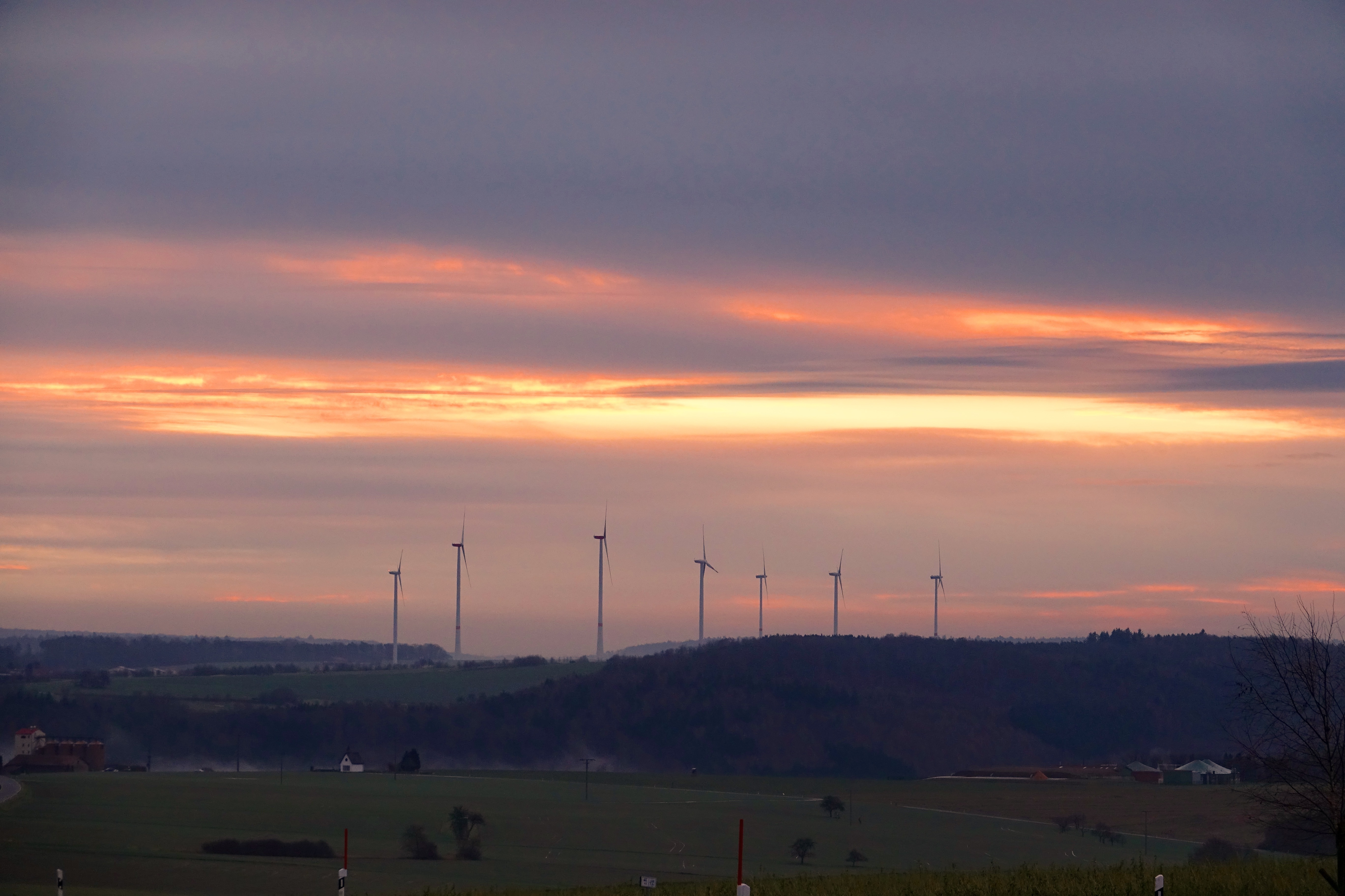 Sonnenaufgang am Dreikönigstag 2018 mit sieben Windkraftanlagen bei Eichenbühl-Guggenberg im Odenwald, Landkreis Miltenberg.