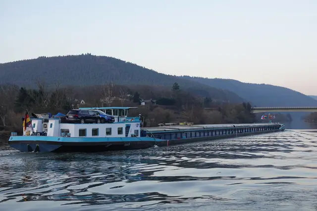 Die „Liütas Dessau“ ist ein modernes Binnenschiff unter deutscher Flagge, das regelmäßig auf dem Main und anderen europäischen Wasserstraßen im Einsatz ist. Mit einer beachtlichen Tragfähigkeit transportiert es verschiedenste Güter wie Rohstoffe, Industrieprodukte oder landwirtschaftliche Erzeugnisse sicher und effizient zwischen wichtigen Umschlagplätzen. Das Schiff steht exemplarisch für den nachhaltigen und leistungsfähigen Gütertransport auf den Binnengewässern Deutschlands, der durch geringe Emissionen und eine hohe Transportkapazität überzeugt.
Der Streckenabschnitt bei Miltenberg gilt als bedeutender Knotenpunkt für die Binnenschifffahrt: Hier treffen historische Traditionen der Schifffahrt auf moderne Logistiklösungen. Die Fahrt mainaufwärts eröffnet dem Frachter Zugang zu neuen Wirtschaftszentren, Märkten und Umschlaghäfen in Süddeutschland und darüber hinaus. Damit spielt die „Liütas Dessau“ eine wichtige Rolle in der Versorgung von Regionen und in der internationalen Handelslogistik.
