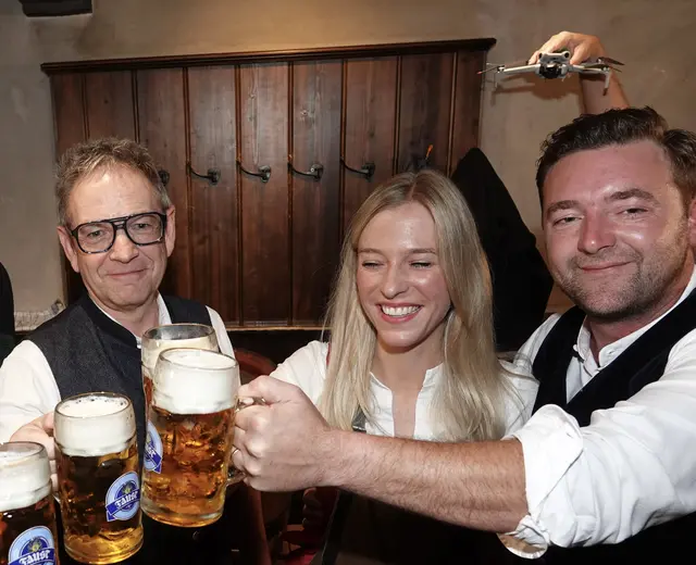 
 „Die Invasion im Wirtshaus“

Im historischen fränkischen Gasthaus roch es nach Tradition, Bier und dem leisen Stolz, dass man wieder einmal ein Fass anzapfen durfte, als hinge das Schicksal der Region davon ab.
Der Ehrengast mit dem Hammer stand bereit, die Fotografen lauerten wie Habichte, die Kameraleute scharrten mit den Objektiven.
Alles wie immer – bis der Mann mit der Drohne auftauchte.
Er war klein, aber sein Gerät groß genug, um als Handgepäck eines Außerirdischen durchzugehen.
Ein Gast fragte vorsichtig:
„Sie werden doch hier keine Drohne im Gastraum fliegen lassen…“

Der Drohnenmann lächelte, als hätte er gerade die Starterlaubnis von der NASA erhalten.
„Nee. Ich halte sie nur in der Hand und lass die Kamera laufen.“

Damit begann die Invasion.

 Die Drohne als außerirdische Heuschrecke

Er führte das Ding durch den Raum wie ein Kind, das endlich das ferngesteuerte Flugzeug bekommen hat, das ihm die Eltern früher verweigerten.
Die Drohne hing vor ihm wie eine Riesenheuschrecke, die gerade beschlossen hat, Karriere im Showgeschäft zu machen.

Die Gäste wichen zurück, manche fasziniert, manche irritiert, manche mit dem instinktiven Reflex, ihre Frisur zu schützen.
Denn die Drohne – obwohl nicht fliegend – tat so, als wäre sie kurz davor, den Luftraum zu übernehmen.

 Finale mit UFO-Ästhetik

Als die Gruppe sich zum Abschlussfoto formierte, schlich der Drohnenmann hinter ihnen entlang und hob sein Gerät über die Köpfe.
Plötzlich sah es aus, als hätten die Menschen im Gasthaus Antennen bekommen.
Hirschgeweihe aus LED-Lichtern, science-fiction-artige Funkstreben, ein Hauch von „Wir kommen in Frieden“.

Auf den Bildern wirkte es, als sei die Delegation der Ehrengäste gerade von einem UFO adoptiert worden.
Man erwartete fast, dass gleich jemand „Beam me up“ ruft.

Fazit:

Die Aliens sind inzwischen unter uns.
Sie tragen Drohnen, halten sie wie Haustiere – und filmen fränkische Bierfeste, als wären es ethnografische Studien über die Menschheit.

